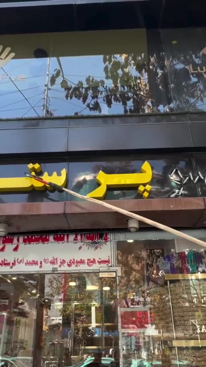 ببینید | اقدام جدید طالبان؛ حذف اسامی غیرافغانی از مغازه‌ها با داس